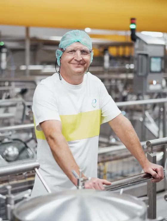 Un homme qui sourit debout dans une usine